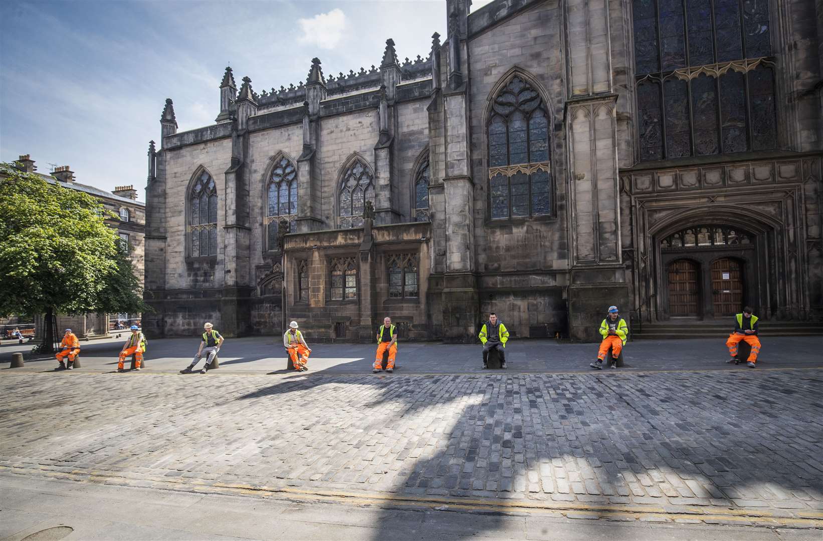 Construction workers comply with social distancing during their break along Edinburgh’s Royal Mile (Jane Barlow/PA)