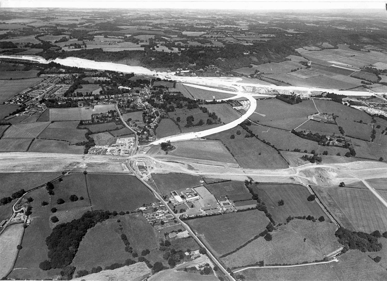 Aerial view of the new motorway being built at Wrotham, in August 1978, the M20 is in the background joined by the Wrotham Bypass