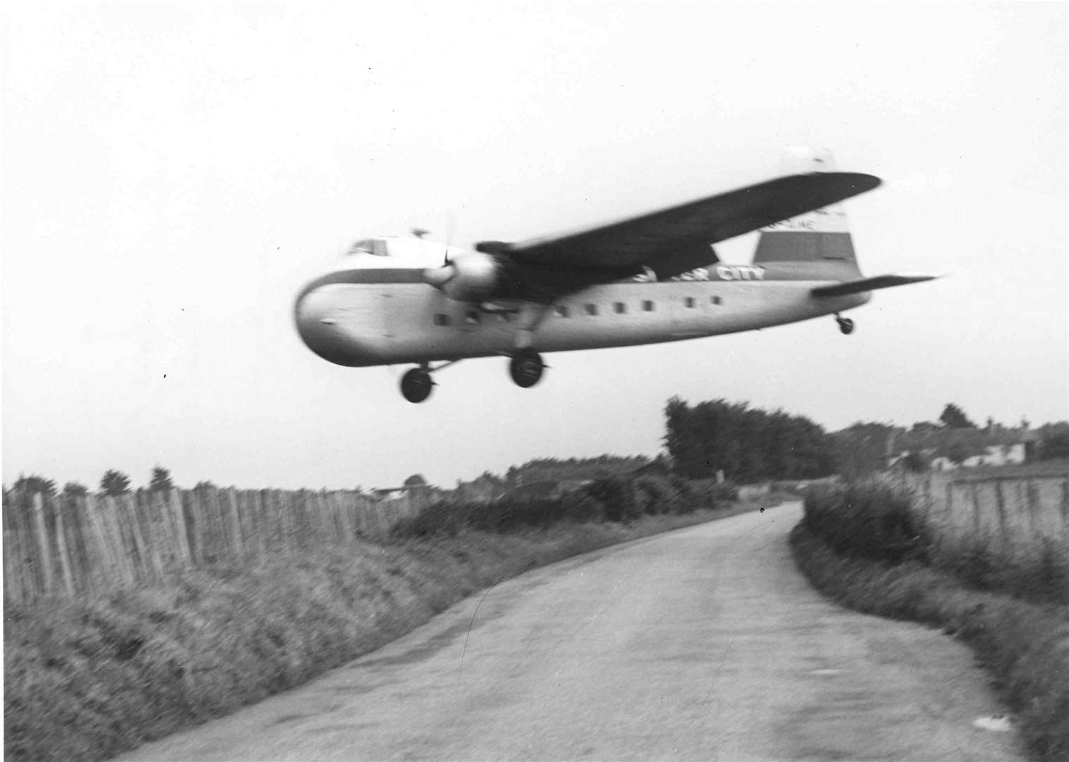A transport plane flies low over the Roman Road at Lympne, near Hythe, in October 1951. Operating from 1916 to 1984, Lympne Airport was used as a military airfield during the First and Second World Wars. In the 1950s, it ran a coach-air service to Paris and back