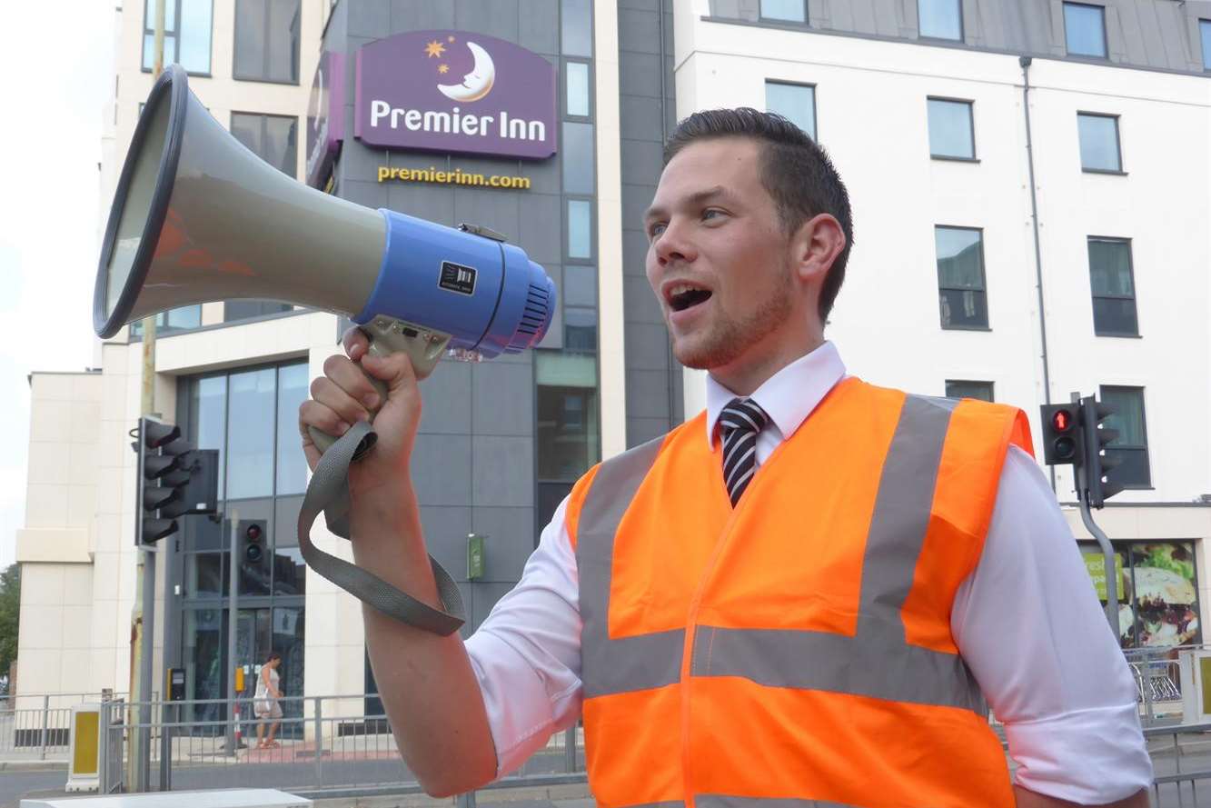 Max Tanner, Operations Manager of Canterbury's Premier Inn, shouts the news that his building is to be used to stage a KM Charity Team abseil on November 1 as part of the hotel's first anniversary celebrations