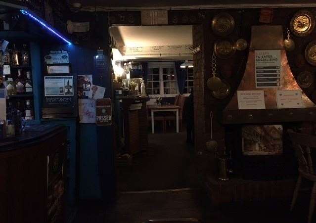 The bar is decorated with fairy lights in the colour of the pub’s name – beyond the bar is the entrance to the dining room