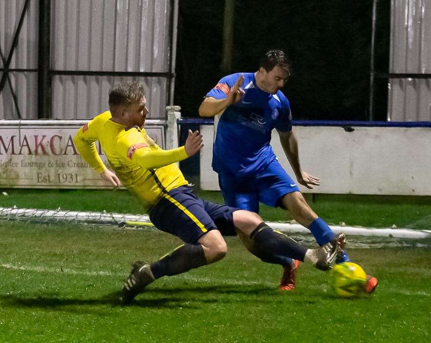 Whitstable's Harry Goodger puts in a firm challenge on Herne Bay defender Dan Johnson. Picture: Les Biggs