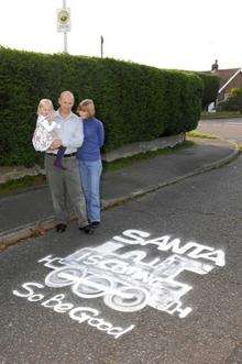 Nigel, Jenny and Amelie Crick look at the paint job. Offensive graffiti on the road in Cherry Gardens, Littlestone has been covered up by the Highways Department with a train and a christmas message.