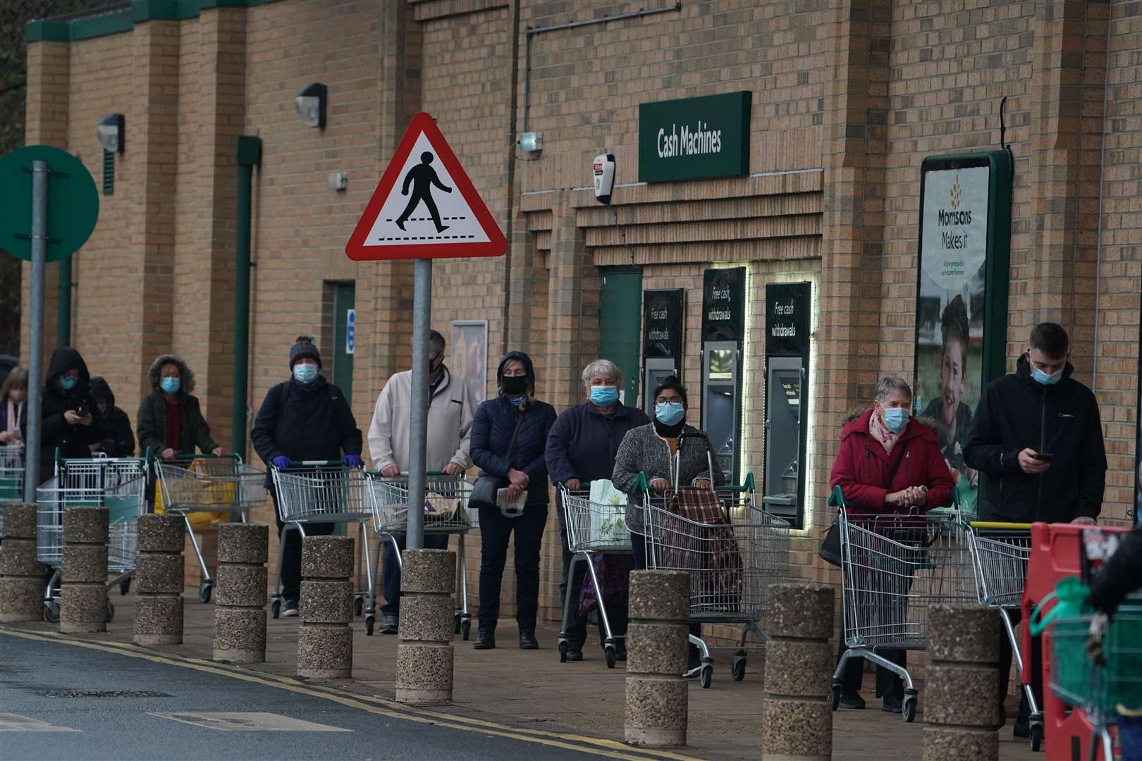 People queue outside a Morrisons supermarket in Whitley Bay, Tyne and Wear (Owen Humphreys/PA)