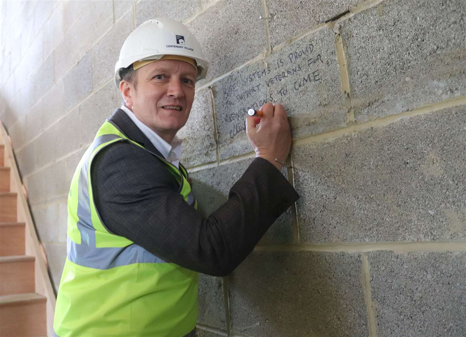 BAE Systems' Rochester Site Director Dave Banks signing the brick of a house for homeless veterans. Picture: RNLI