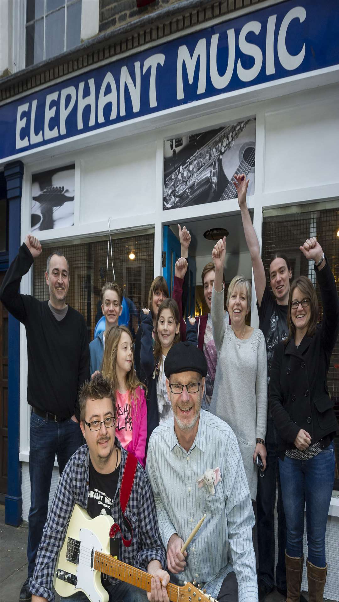 New managers Rob Sherwood, front left, and Dennis Halberg, front right, with guests at the opening of Gravesend's only music store, Elephant Music