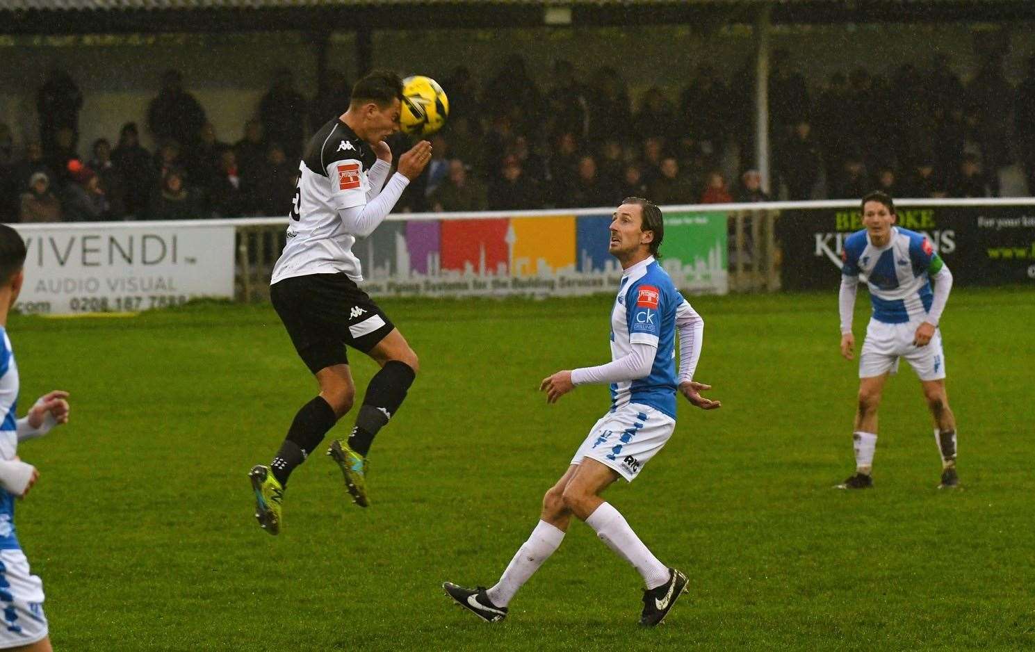 Faversham's Connor Wilkins heads forward under pressure from Sheppey player-boss Jack Midson. Picture: Marc Richards