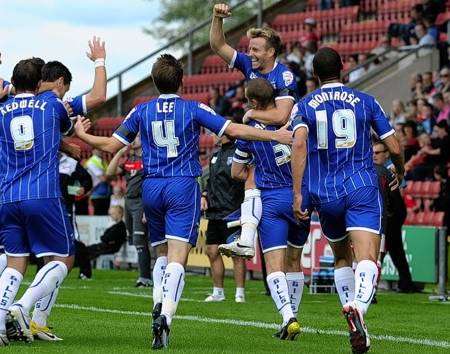 Danny Spiller is mobbed by his team mates after putting Gillingham 2-0 ahead at Crewe
