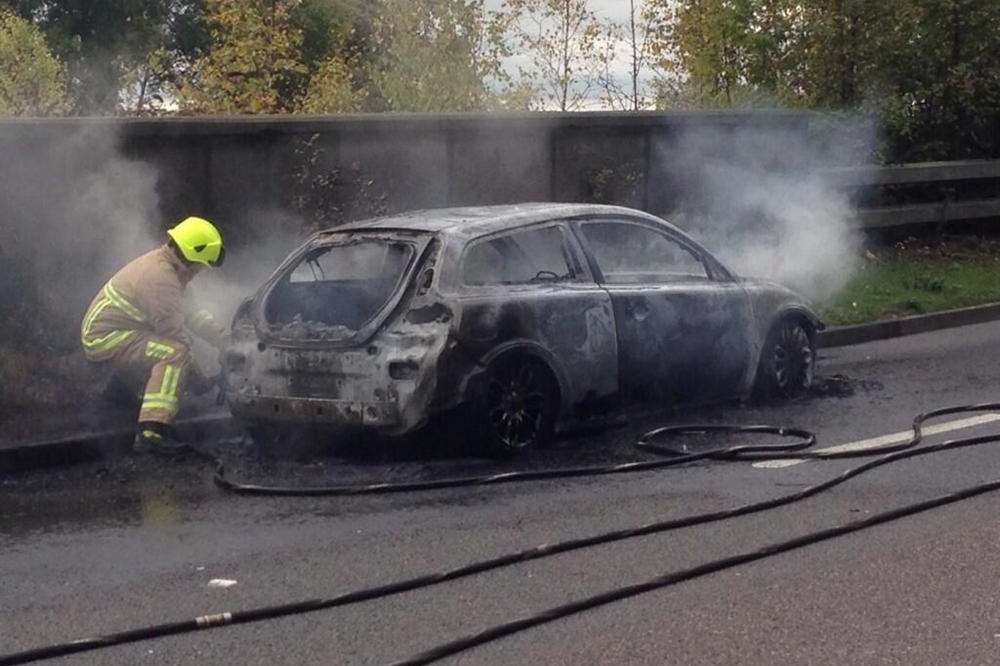Fire crews and police deal with a car fire