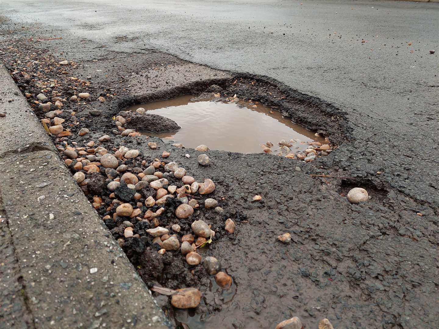 A pothole in Kennington, Ashford - and more could be set to appear over the coming weeks
