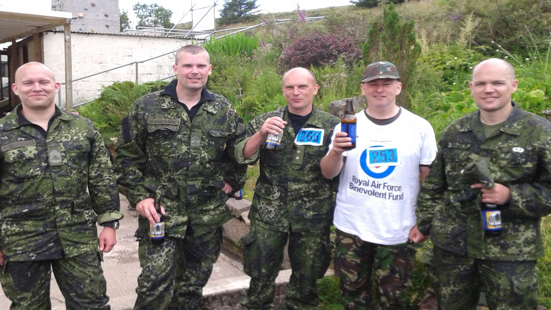 Richard is joined by Danish soldiers celebrating with a beer after completing the challenge