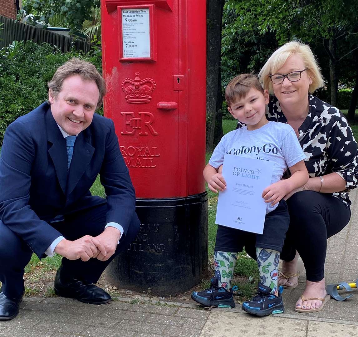 MP Tom Tugendhat presents Tony, pictured with his mum, with a reward from the Prime Minister
