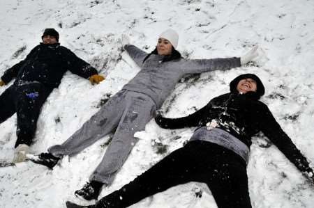 Guido Spocchia, Anna Box and Adelle Montgomery making snow angels at The Glen, Minster