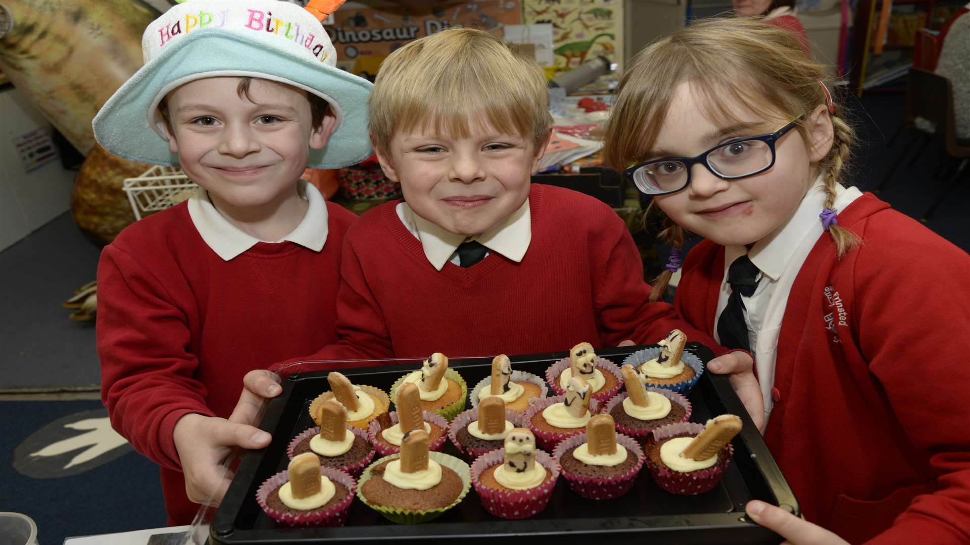 Young entrepreneurs George, seven, Edward, six and Amelia, six with their cakes