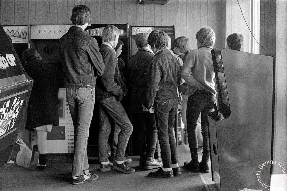 A group huddled around a machine. Copyright: George Wilson
