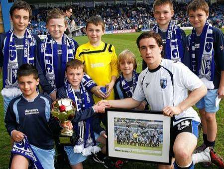 Herne Bay Junior School's year 3 football team are presented with a signed team photo by Gillingham midfielder Luke Rooney