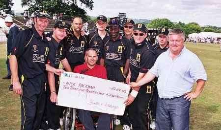 Nick Packham receives his cheque from David Folb, right, and members of the World X1