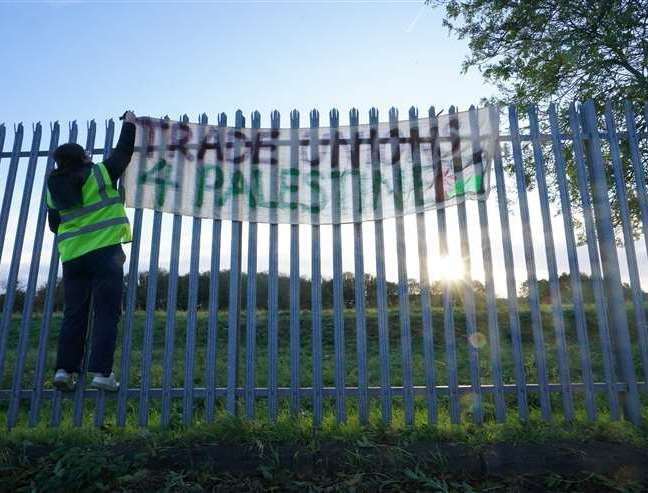 A protester hangs a banner on a fence outside weapons manufacturer BAE Systems in Rochester. Photo: Gareth Fuller/PA