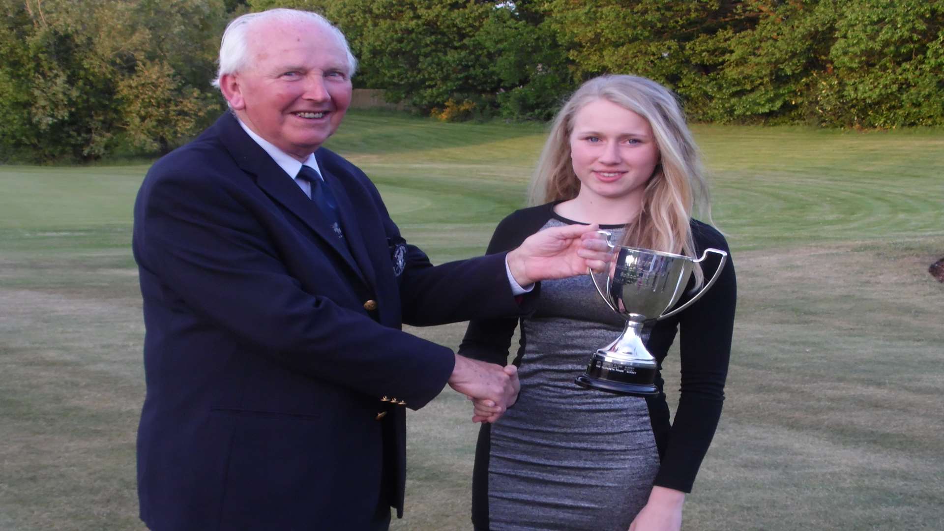 Nicole Amos receives the English Schools South Region Trophy from Kent Schools secretary Richard Young