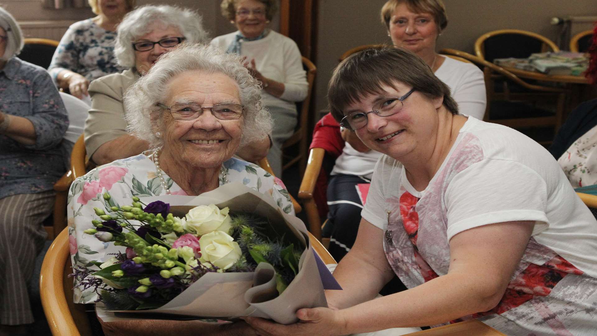 Alice White is presented with some birthday flowers from Lesley-Anne Farrell, President of the WI.