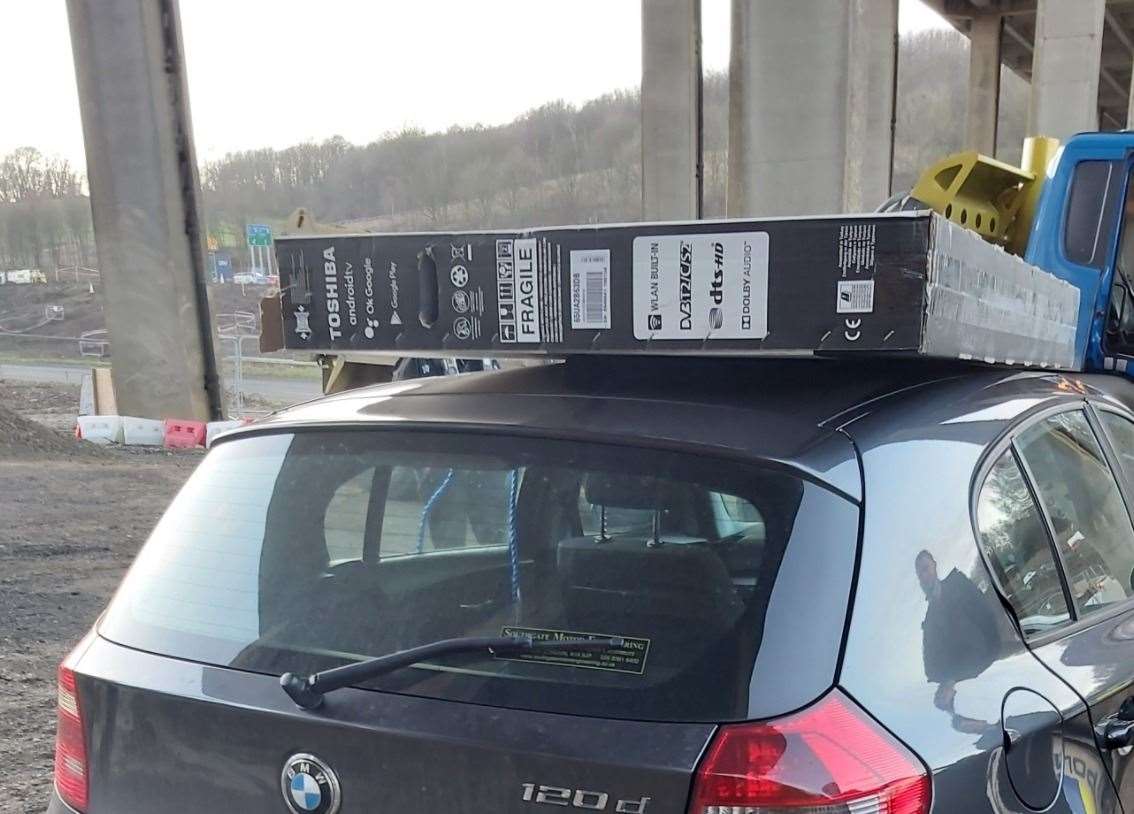 A stolen Toshiba TV was spotted tied to the roof of a BMW. Picture: Kent Police Swale/Twitter