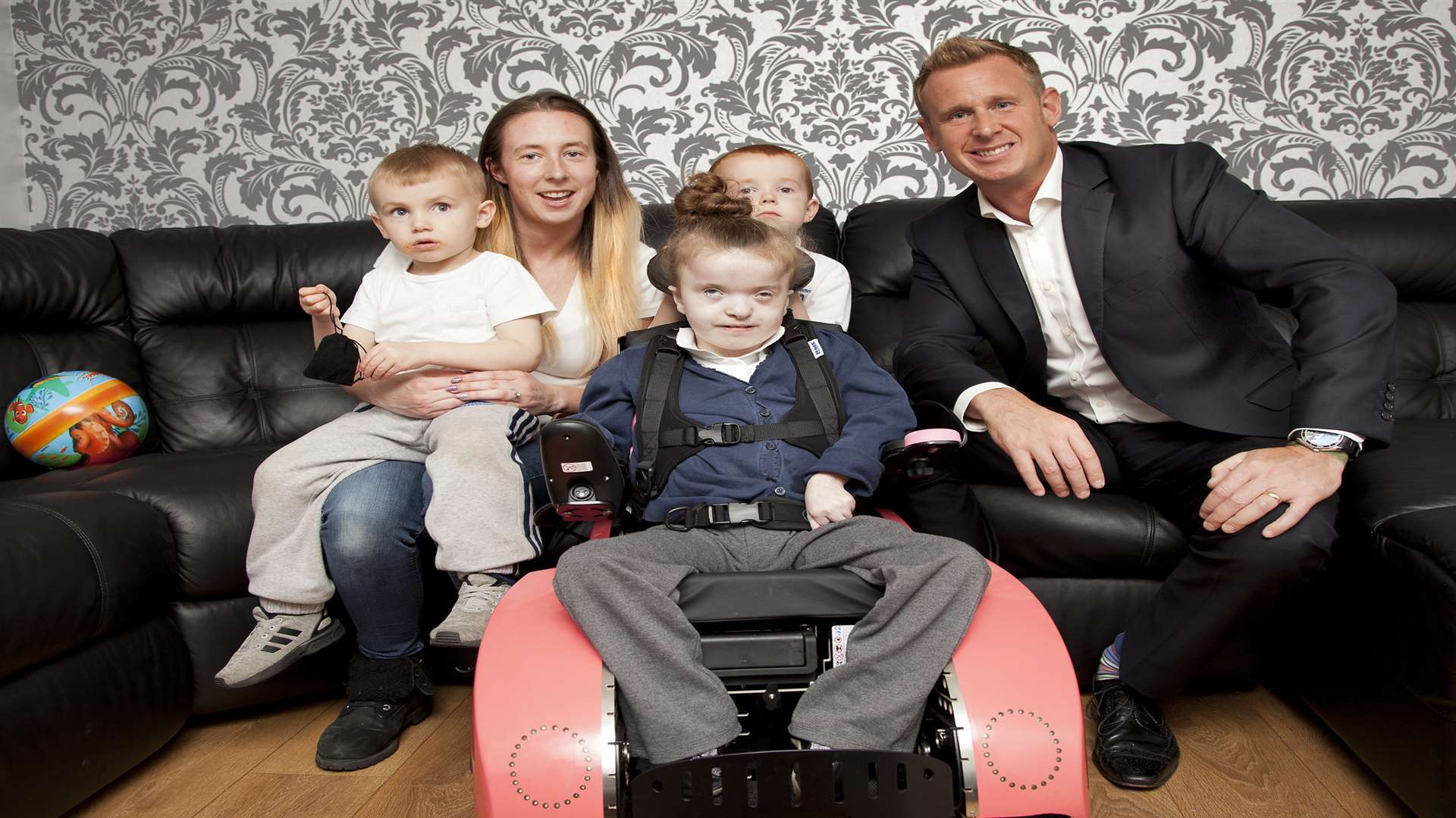 Lilly-Ann Robertson, eight, from Sheerness, gets her £6,000 TinyTRAX power chair from Donations With A Difference's chairman Wayne Hodgson, along with mum Roxanne and brothers William and Tommy