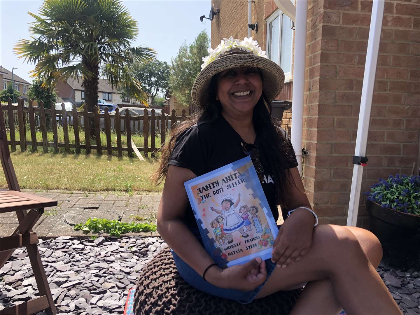 Michelle with her children's book 'Tanty Anita The Roti Seller'.