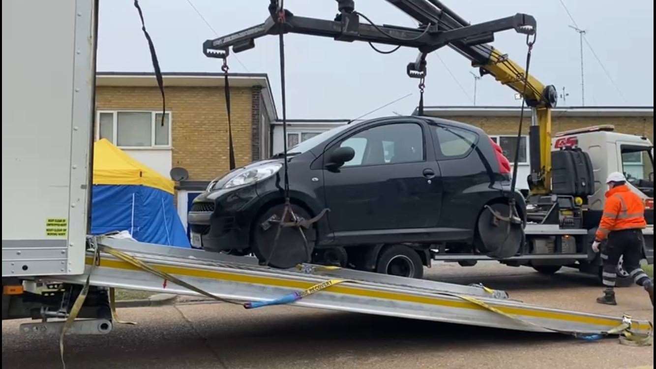 A second car is being removed from the scene