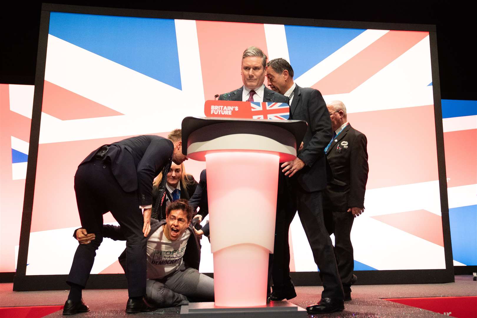 A protester, who named himself as Yaz Ashmawi, throws glitter over Labour leader Sir Keir Starmer before his keynote speech at the Labour Party Conference in Liverpool. Picture date: Tuesday October 10, 2023.