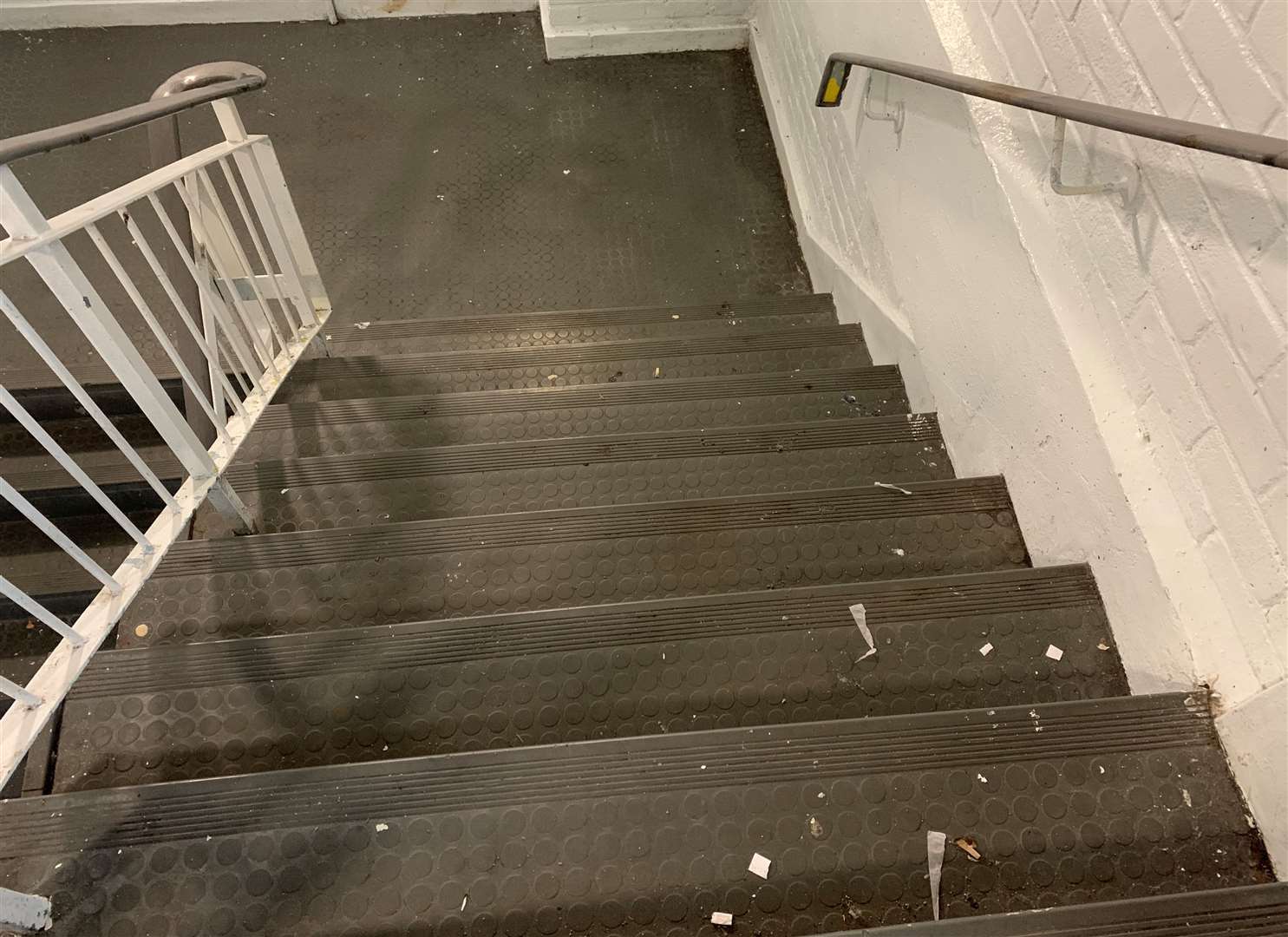 There are discarded cigarette butts on the stairs in the car park