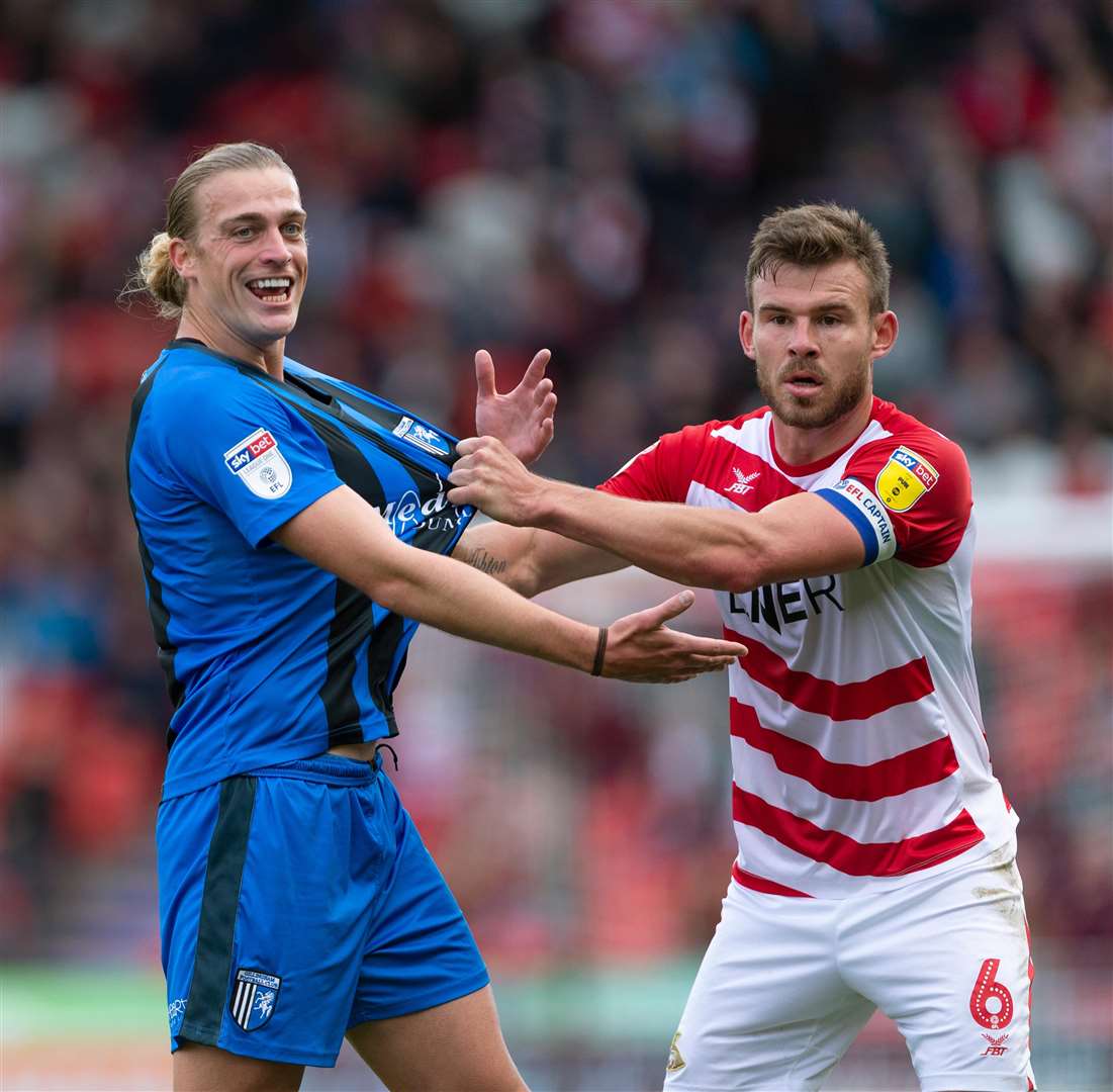 Gills striker Tom Eaves is manhandled by Doncaster's Andy Butler Picture: Ady Kerry