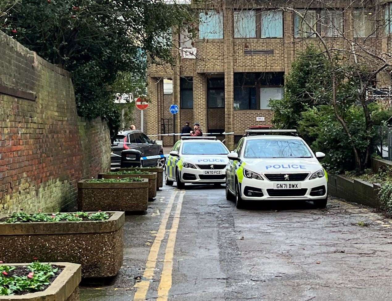 Three police cars were parked at the junction with Church Road, including an unmarked Volvo