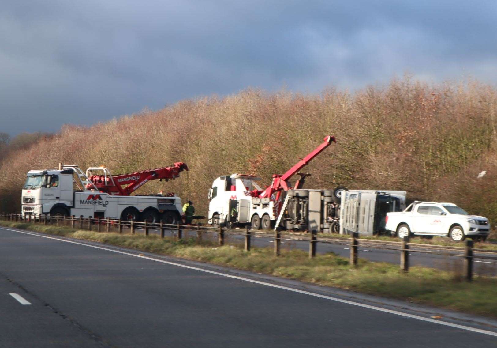 Two recovery trucks attempt to right an overturned lorry on the Sheppey-bound A249 at Bobbing