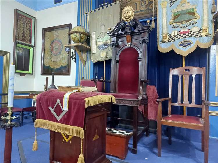 À une extrémité de la salle se trouve une chaise surélevée en forme de trône