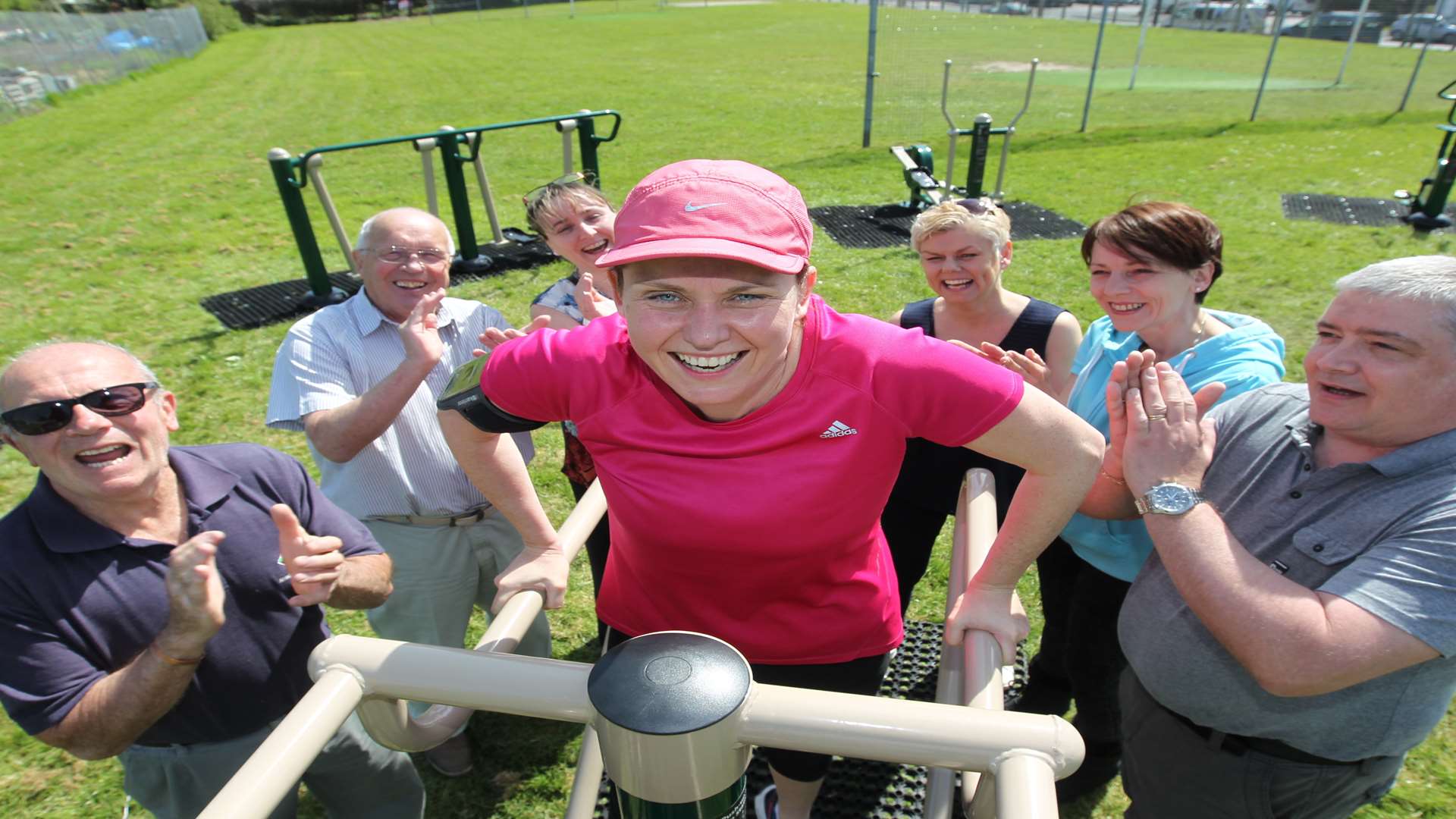 Evie Ashley, resident in pink, doing exercise on new park equipment with from left, Keith Impiazzi, parish councillor, Dave Hammock, Borough Councillor, Tracey Williams, resident, Carolyn Drayson, resident, Anna Munday, parish councillor and Keith Burgin, parish councillor, giving her encouragement in Bean Park.