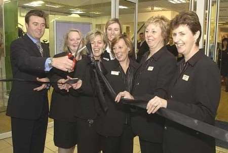 WE'RE OPEN: Mark Newton-Jones cuts the red tape to reopen Littlewood's Ashford store with several long-serving members of staff. Picture: DAVE DOWNEY