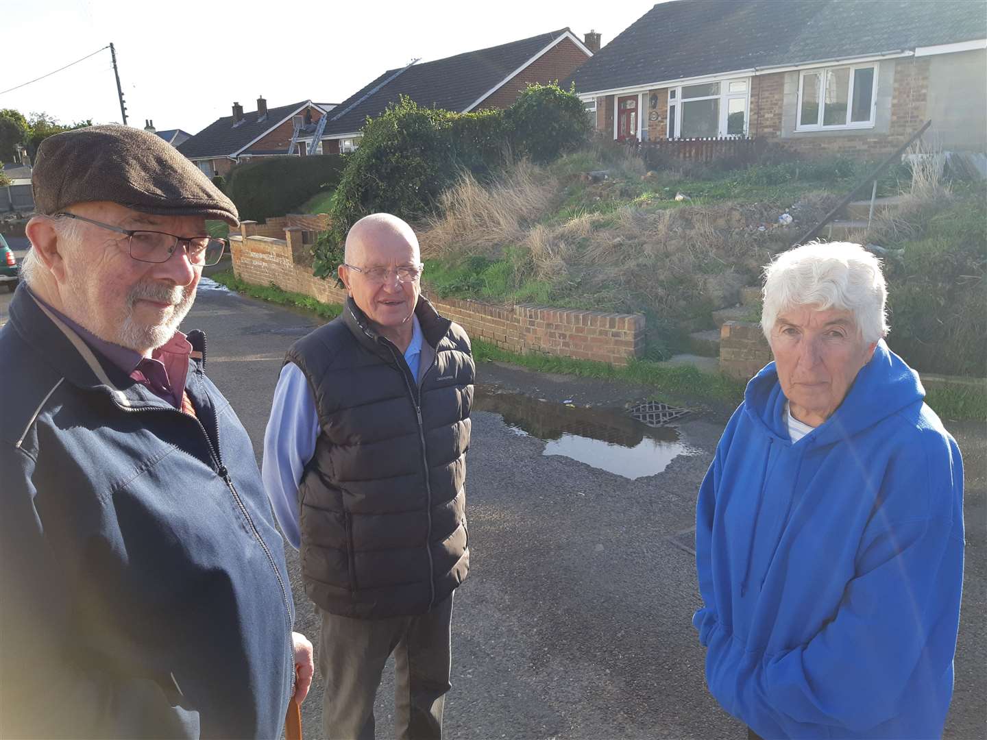 Cllr Wanstall with neighbours Alan and Sheila Walton and the leak in the background. Picture: Sam Lennon KMG