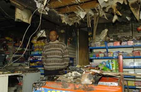 AFTERMATH: Postmaster Kanagasaundaram Prince surveys the damage to the front of his store. Picture: ANDY PAYTON