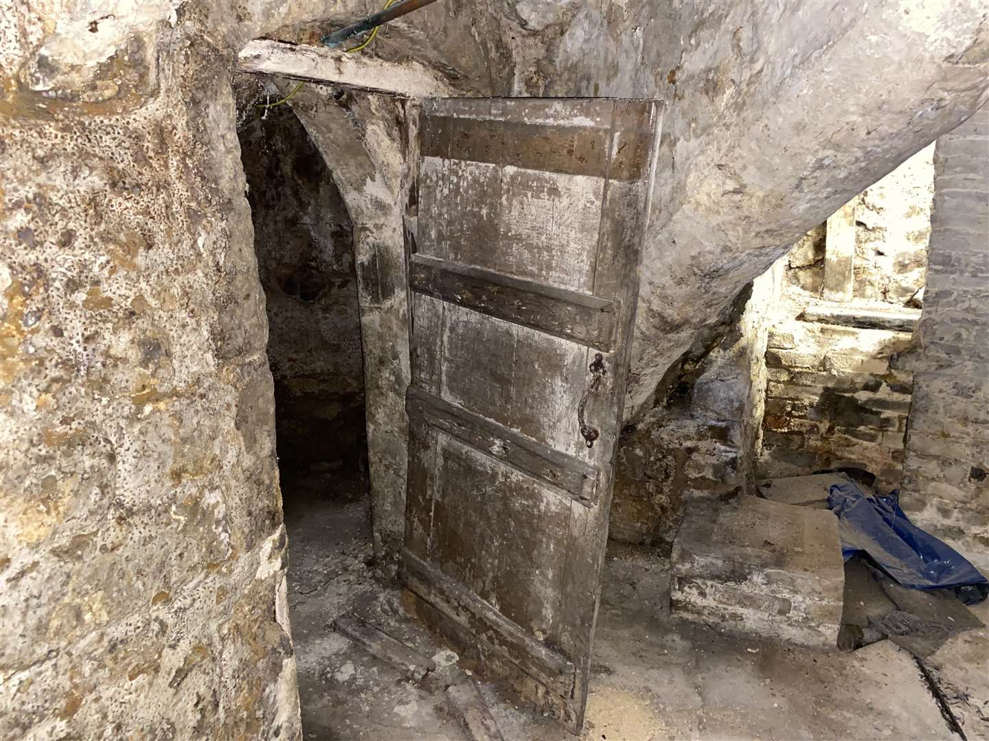 An ancient-looking door hangs in the crypt