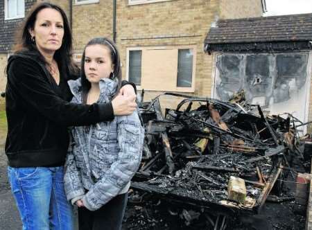 Lisa Coster and her daughter, Shanelle, with the burnt-out caravan
