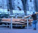 This man loads some of the wood onto a vehicle