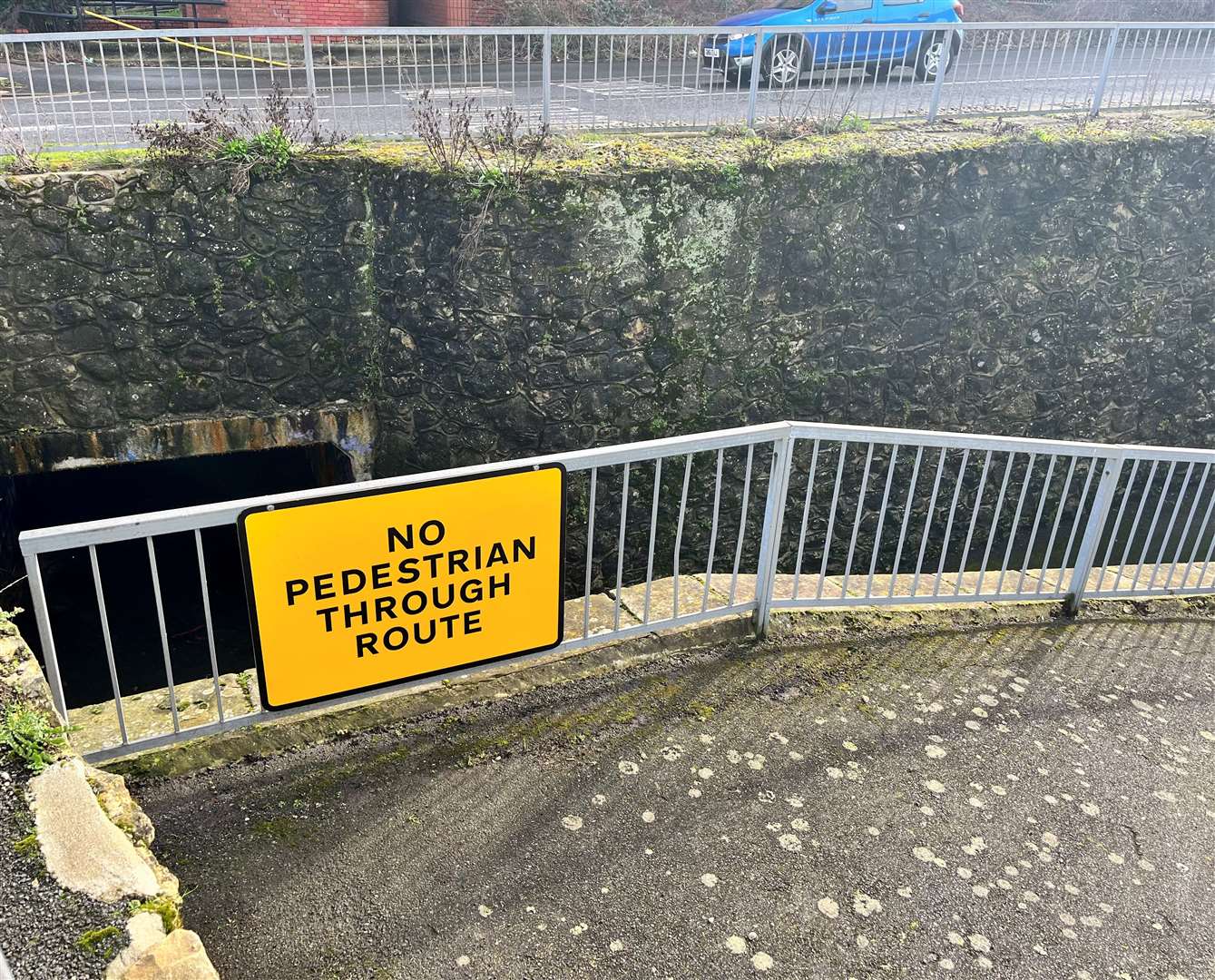 A sign above the entrance to the underpass which says 'no pedestrian through route'