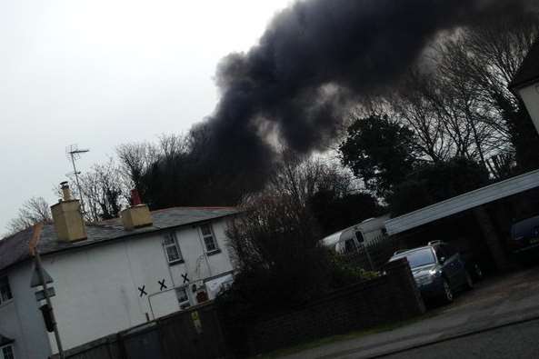 Smoke can be seen billowing out from behind houses