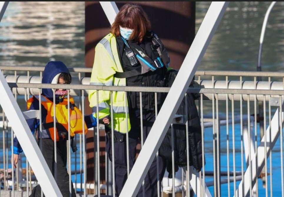 A child taken to safety along the gangway by an official. Picture: UKNIP