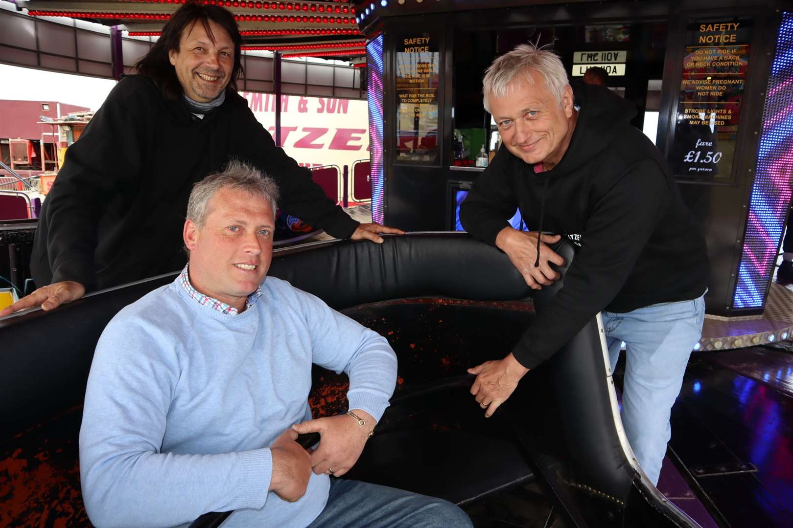Cllrs Mike Baldock, left, and Richard Palmer give funfair boss Carlos Christian a hand on the waltzer at Smith's funfair at Barton's Point, Sheerness. Picture: John Nurden