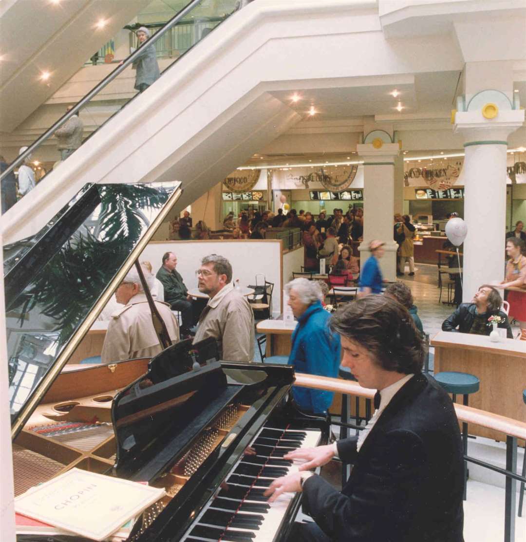 A man plays the piano in the Royal Victoria Place