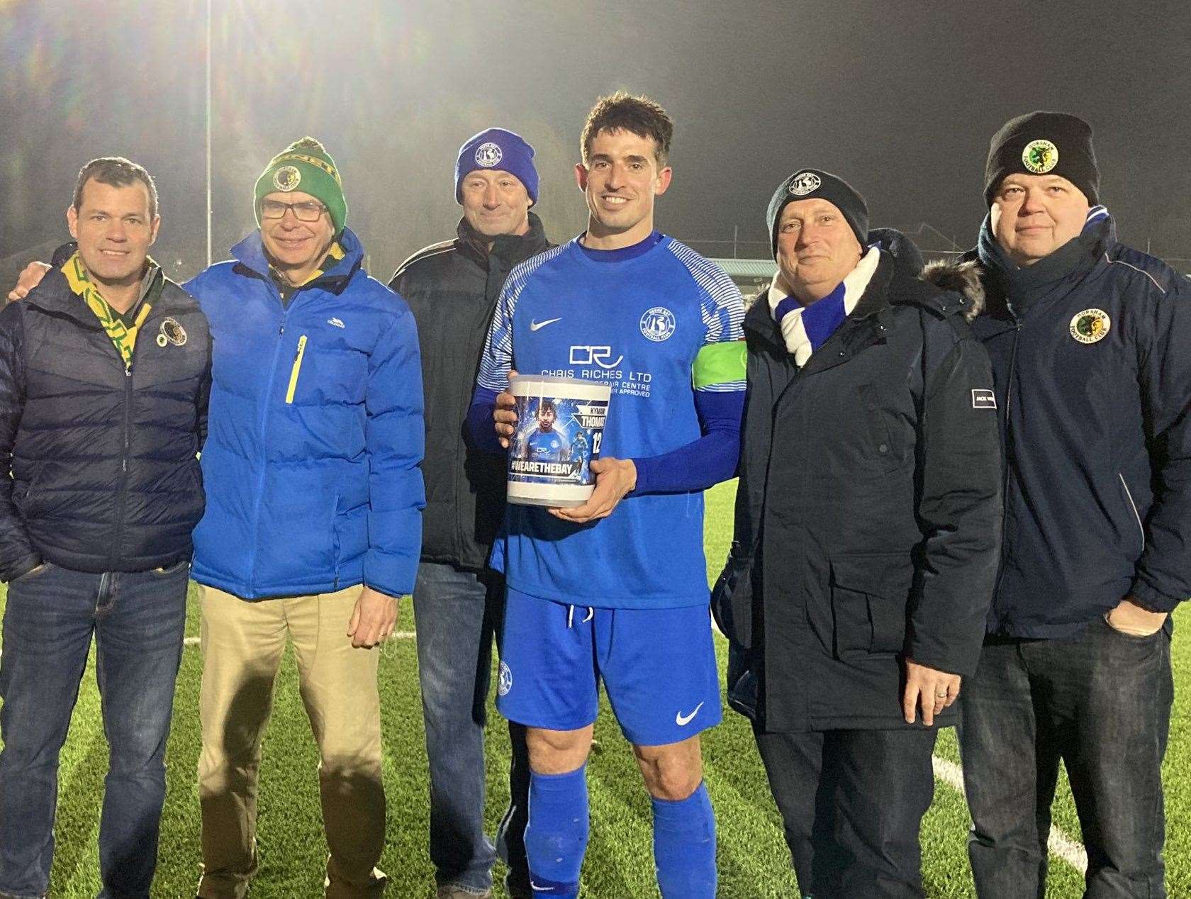 Herne Bay captain Laurence Harvey is presented with funds to support injured striker Kymani Thomas' recovery by officials from Herne Bay and opponents Horsham