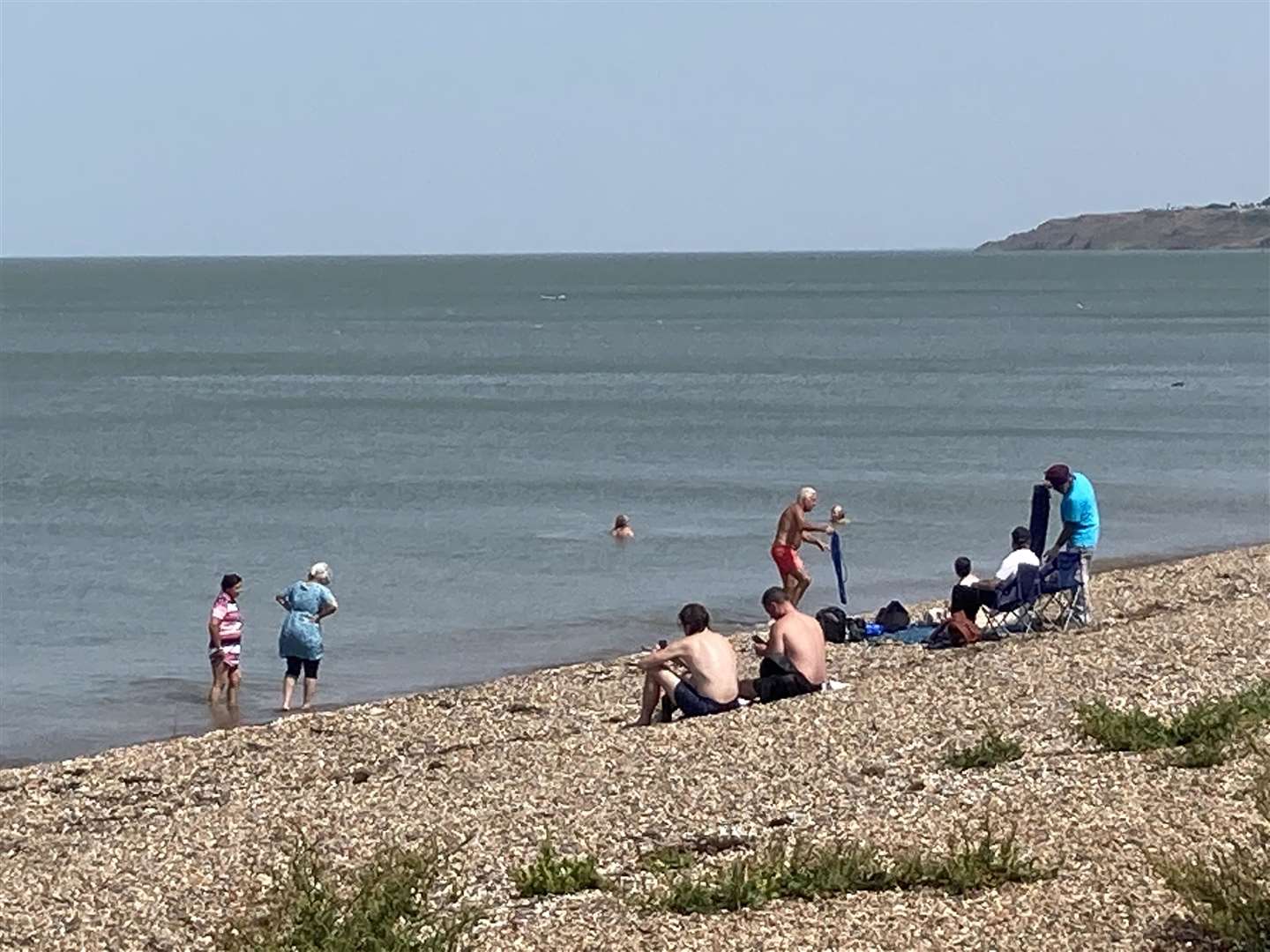 Swimmers take a dip to cool off at the beach at Minster on the sun-kissed Isle of Sheppey on the hottest day of the year so far