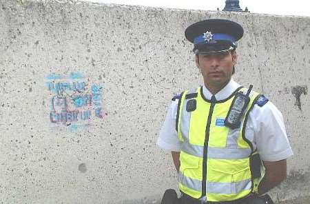 Police community support officer Alamgir Sheriyar with some of the graffiti before it was cleaned off
