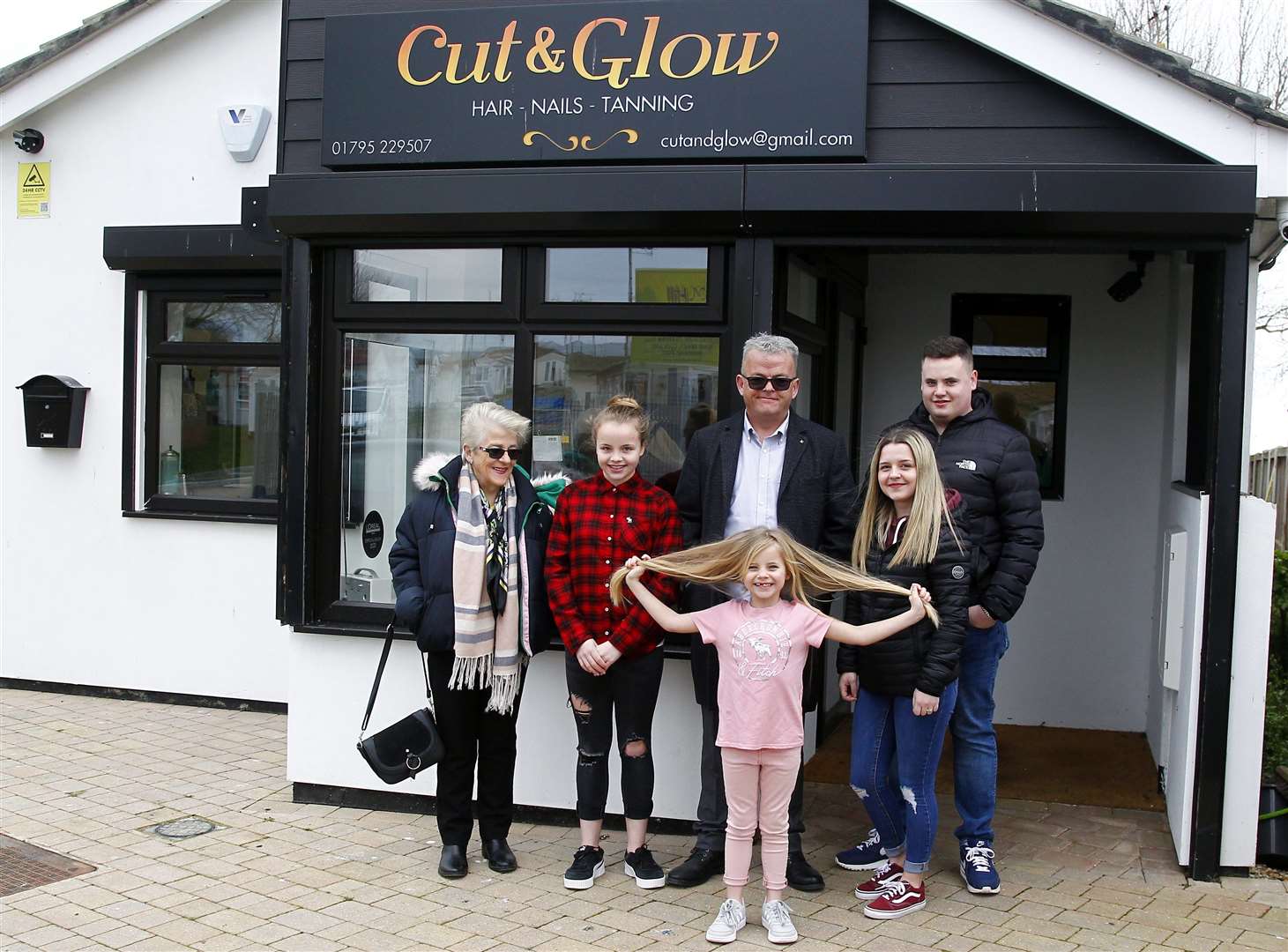 Tilly, front, and family outside Cut and Glow in Leysdown before she had the chop